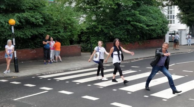 Tourists stride across the fabled Abbey Road crossing